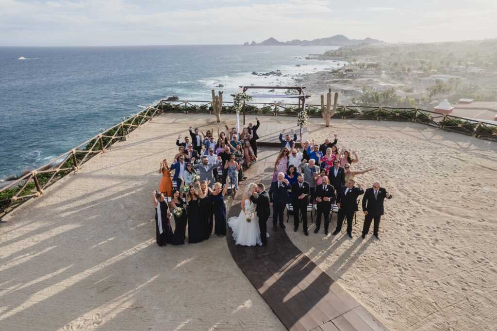 Destination wedding ceremony at Hacienda Encantada in Los Cabos, Mexico, with a stunning backdrop of ocean and desert views.