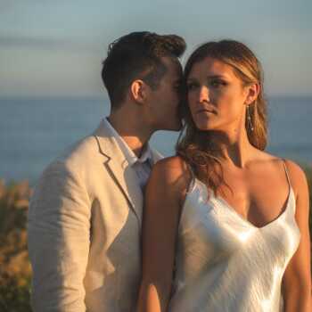 Couple embracing with a dramatic ocean backdrop in Los Cabos, capturing the essence of a destination wedding. Cover image for 'How to Plan a Destination Wedding in Los Cabos: Expert Tips from a Cabo Wedding Photographer and Videographer.